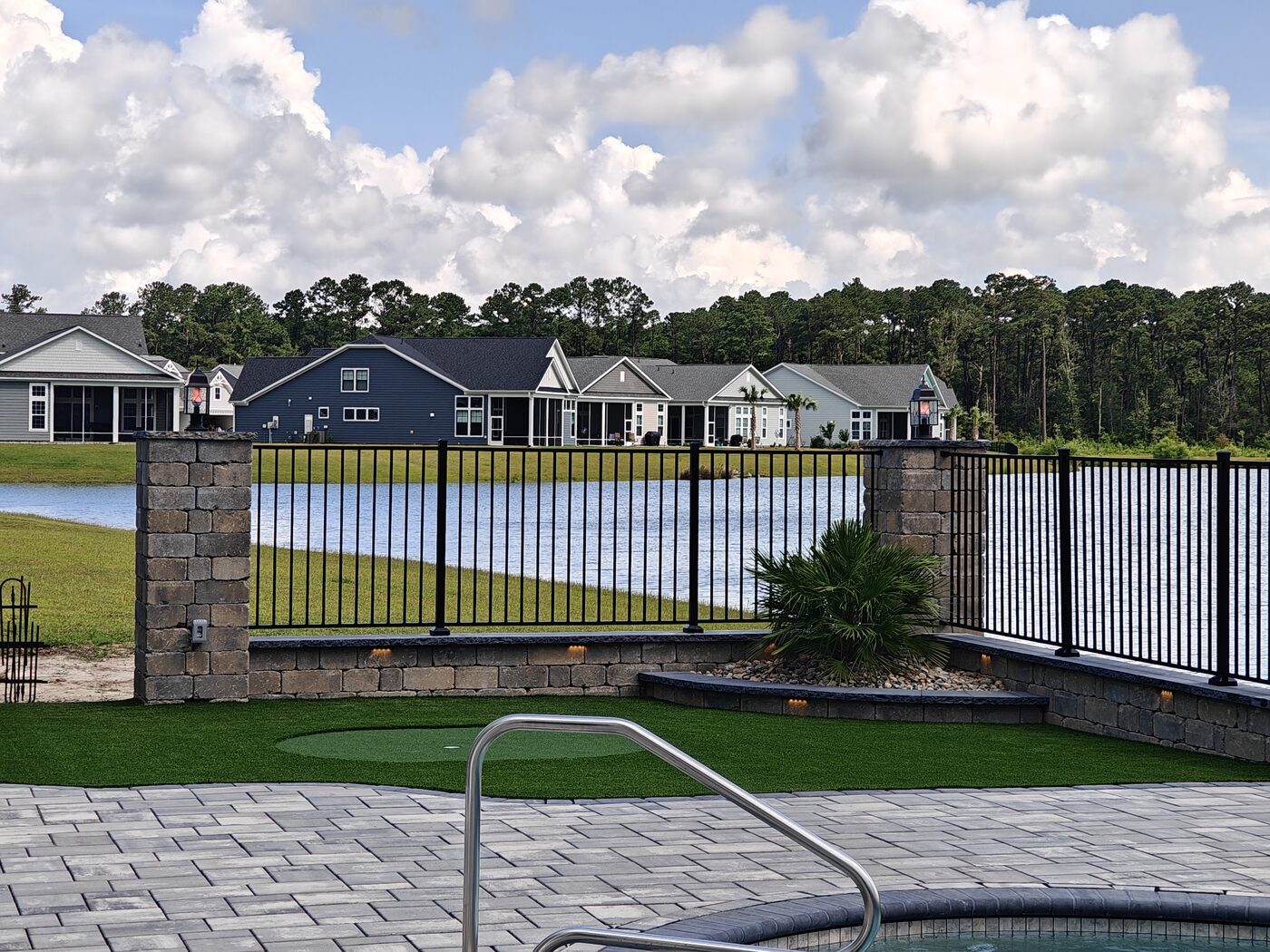 Black aluminum ornamental fence with stone columns
